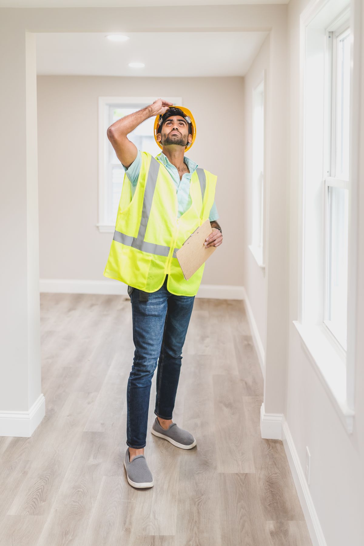Inspector in a safety vest looking at a ceiling